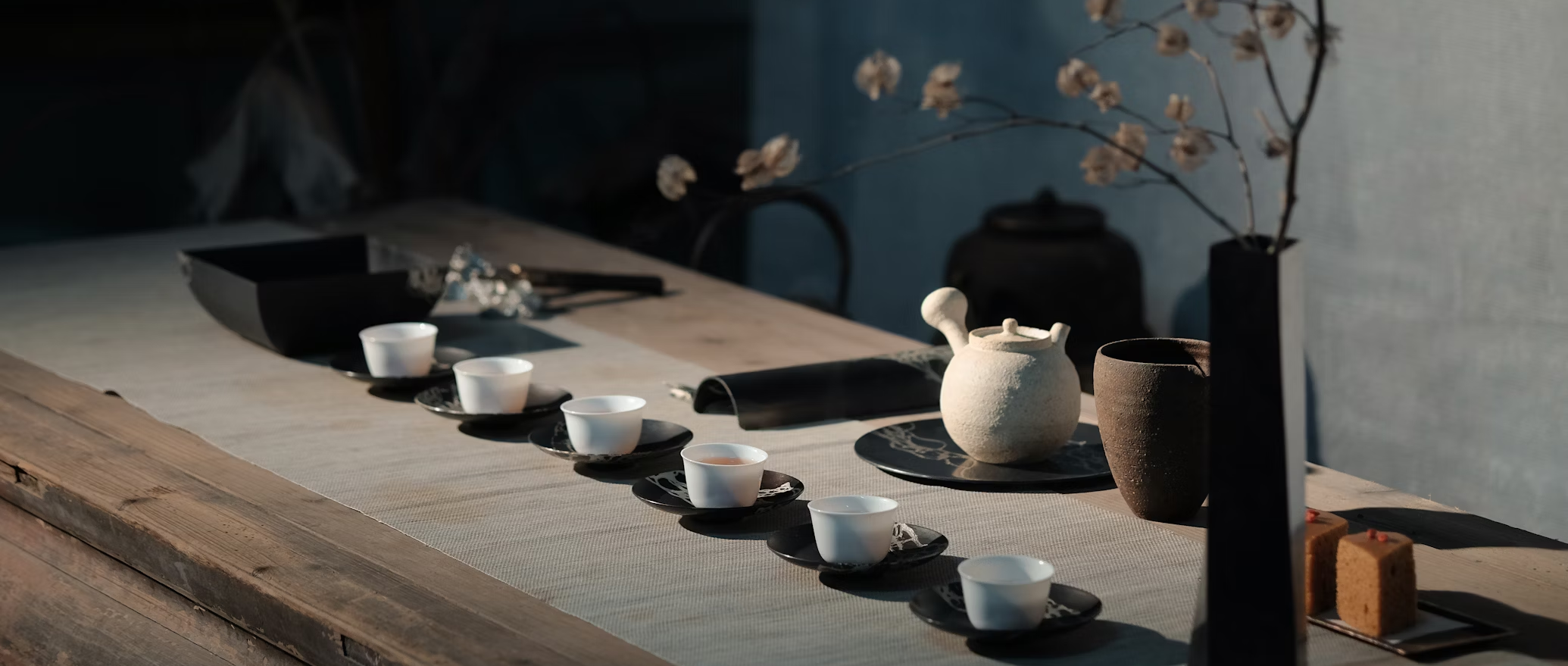Aligned green tea cups arranged neatly in a row, set against a wooden tray, showcasing the serene elegance of a traditional Japanese tea ceremony.